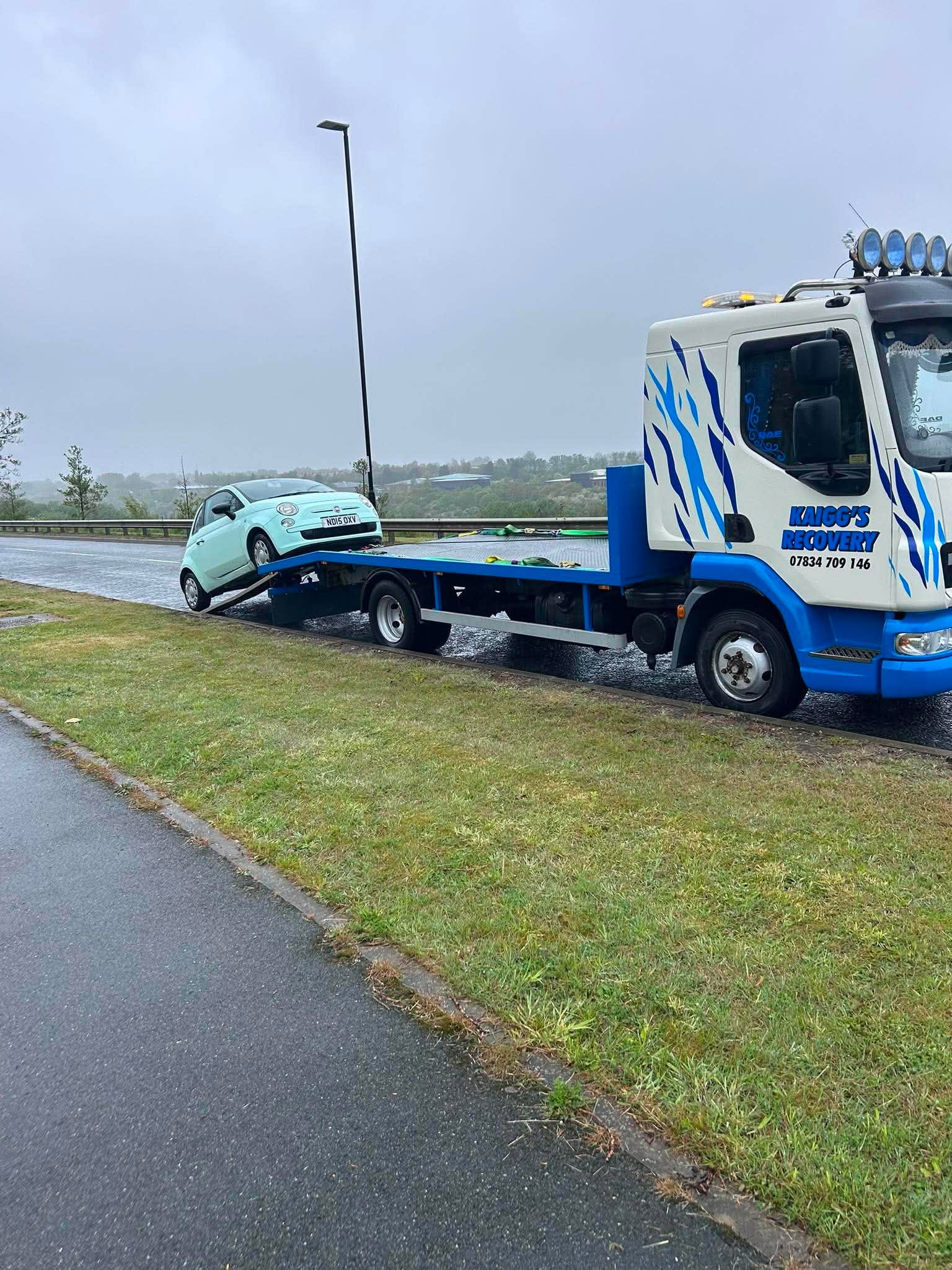 Kaigg's Recovery flatbed truck recovering a car in the rain